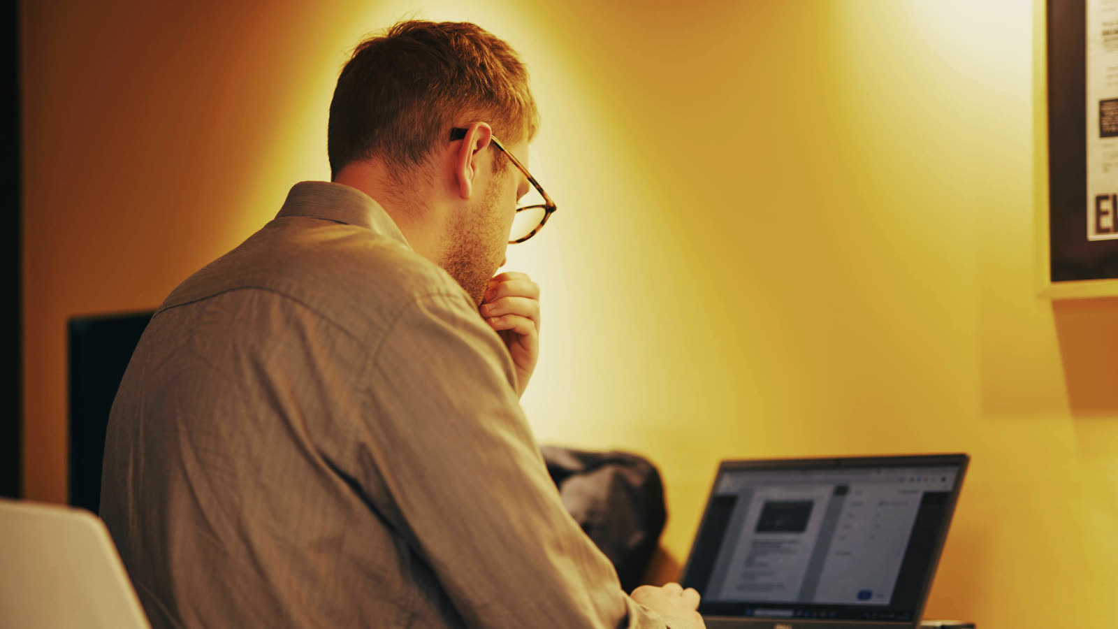 A Rostrum consultant at his desk by the studio's yellow wall